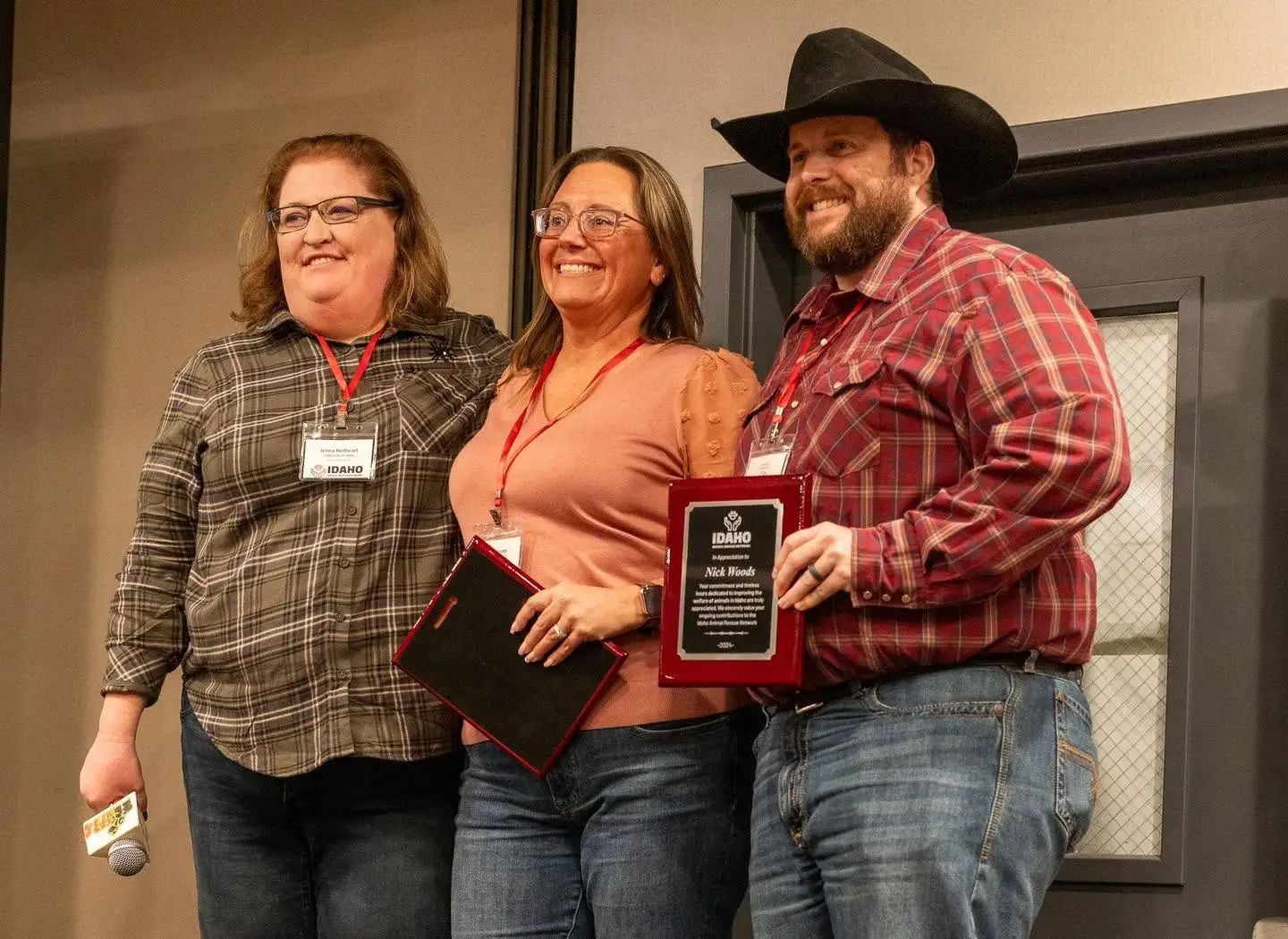 Three people posing with Pawtner Award plaques