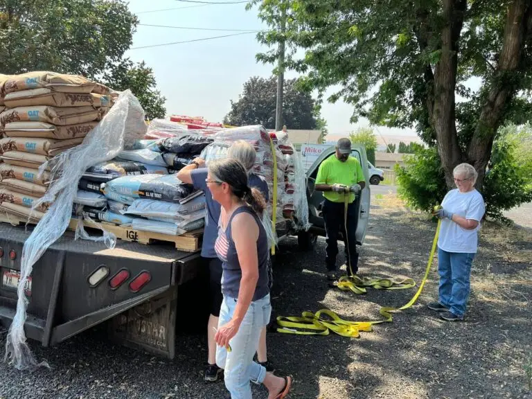 Idaho Animal Rescue Network volunteers unloading donated pet food and supplies from a truck and trailer